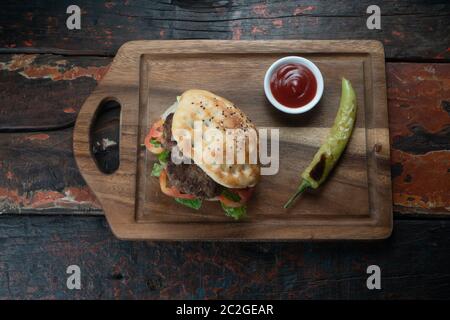 Kofte Ekmek turc. Sandwich au meatball avec tomates, oignons et poivrons verts isolés sur fond rustique en bois Banque D'Images