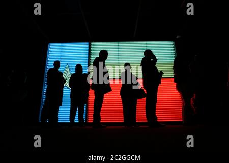 San Antonio Texas Etats-Unis, 25 mars 2016: Les gens qui se tiennent en ligne à l'Institut des cultures texanes sont silhouettés contre un grand fluo rendu d'un drapeau du Texas. ©Bob Daemmrich Banque D'Images