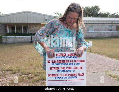 Goliad, Texas, États-Unis 26 octobre 2016: Le responsable électoral Becky Ward ajuste un marqueur de distance à l'extérieur d'un lieu de vote à l'ouverture du vote pour l'élection générale de 8 novembre. Aucune campagne électorale n’est autorisée au-delà du signe pour empêcher les électeurs d’être harcelés par des personnes en campagne pour les candidats. ©Bob Daemmrich Banque D'Images