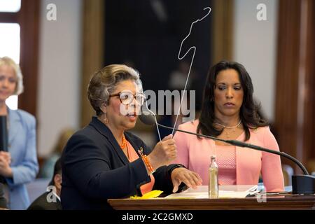 Austin Texas États-Unis, 10 juillet 2013: La Représentante de l'État Senfronia Thompson, D-Houston, détient des outils primitifs d'avortement (des cintres reconfigurés pour le pelage), tandis que les législateurs texans luttent pour adopter un projet de loi qui limiterait le nombre de prestataires d'avortement en augmentant les normes médicales pour les cliniques au niveau des centres chirurgicaux ambulatoires. ©Bob Daemmrich Banque D'Images