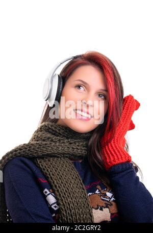 Belle jeune fille souriante avec écharpe et mitaines, écoute de la musique sur son casque, isolé sur fond blanc. Banque D'Images
