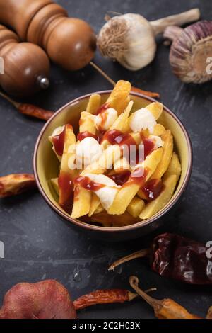 Poutine canadienne, frites de pommes de terre au fromage et sauce ou sauce Banque D'Images