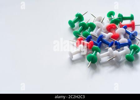 Objets de bureau ou d'école. Broches à poussoir multicolores isolées sur fond blanc. Collecte des punaises Banque D'Images