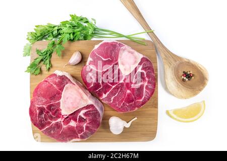 Tiges de veau d'Ossobuco avec persil, citron et ail pour une gremolata, ingrédients typiques de la cuisine italienne Lombard, plat sur un Banque D'Images