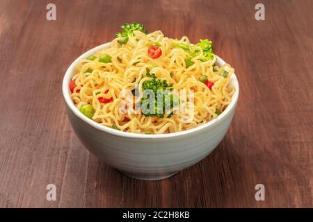 Nouilles Soba avec brocoli et poivrons rouges sur un fond de bois rustique foncé Banque D'Images