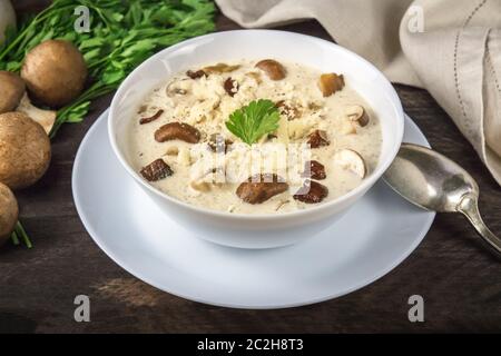 Soupe aux champignons avec des ingrédients sur un fond de bois rustique foncé, selective focus Banque D'Images
