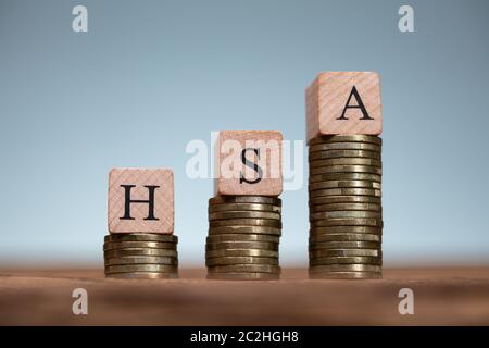 Compte d'épargne santé HSA des blocs de bois sur les piles de pièces de monnaie Banque D'Images