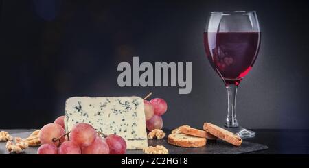 Un panorama de fromage gorgonzola avec vin rouge sur un fond sombre avec copie espace Banque D'Images