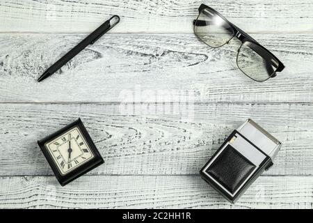 Réveil matin. retro vintage, lunettes, rasoir électrique et les verres optiques sur fond de bois blanc minable Banque D'Images