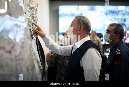 Ankara. 17 juin 2020. Le ministre turc de la Défense Hulusi Akar (front) examine une carte du Centre de contrôle du commandement de l'armée à Ankara, Turquie, le 17 juin 2020. La Turquie a lancé l'opération Claw-Tiger dans le nord de l'Irak avec ses forces de commandement soutenues par des éléments aériens, a annoncé mercredi le ministère turc de la Défense. Crédit: Xinhua/Alay Live News Banque D'Images