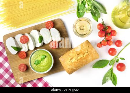 La cuisine italienne et le vin. Fromage Mozzarella, pain ciabatta, basilic, pesto. La cuisine de l'Italie sur un fond blanc Banque D'Images