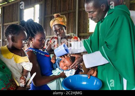 Baptême d'un enfant pendant un service catholique dans la chapelle du village de Nzulezo dans le lac Amansura / Ghana Banque D'Images