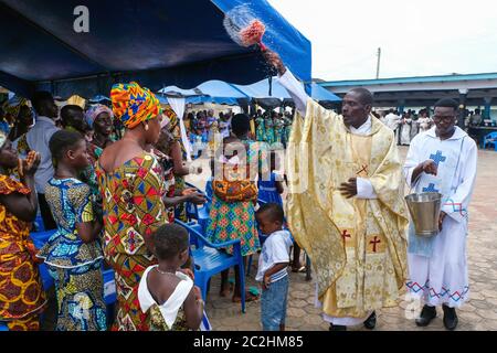 Le prêtre catholique Rév. FR. Anthony Assebiah bénit les fidèles avec de l'eau consacrée. Messe du dimanche paroissial de Sainte-Marie à KenGen, Ghana, Afrique Banque D'Images