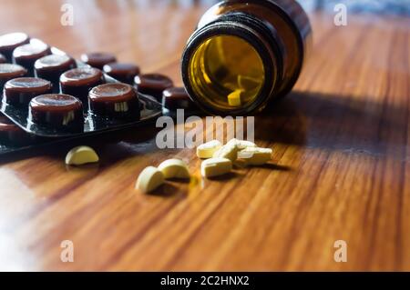 Fermer Ouvrir le flacon en verre transparent avec la médecine pilules ou de comprimés sous blister sur fond de table en bois. Le concept de la santé et guérison de la pharmacie. Selec Banque D'Images