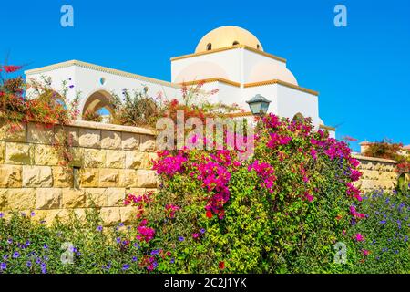 Façade en fleurs du Belvédère dans la vieille ville de Sahl Hasheesh - la célèbre belle allée, entourée de bâtiments d'architecture arabe. Banque D'Images