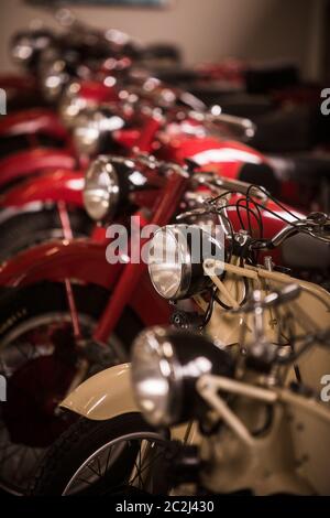 Une rangée de motos anciennes en stationnement, à l'intérieur. Banque D'Images