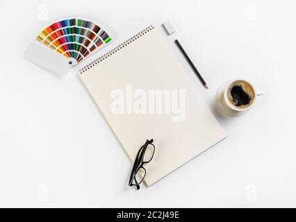 Kit papeterie vierge. Sketchbook, palette de couleurs, verres, tasses à café, un crayon et une gomme. Mise à plat. Banque D'Images