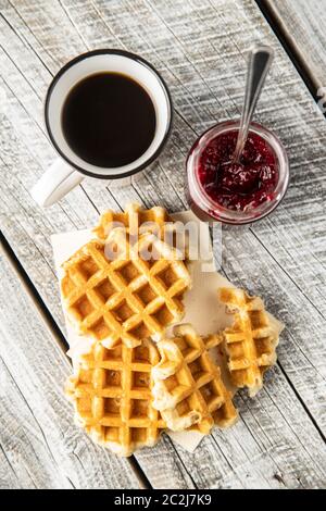 Gaufres sucrées savoureux avec confiture de framboises et tasse de thé. Vue d'en haut. Banque D'Images