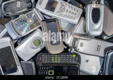 Pile de vieux téléphones portables à recycler. Il existe une variété de téléphones, mais la plupart sont le type de bascule pour ouvrir. Les téléphones sont sales. La marque a été supprimée Banque D'Images