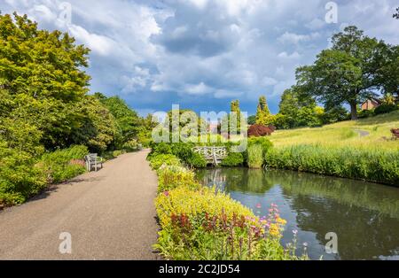 Vue dans RHS Garden Wissley du ruisseau et des étangs entre Oakwood et Alpine Meadow and Rock Garden, en été Banque D'Images