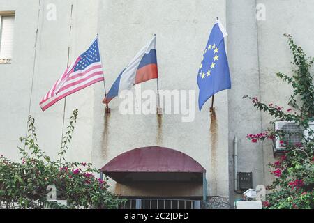 Les drapeaux américains, russes et européens flottent sur le mur d'un bâtiment Banque D'Images