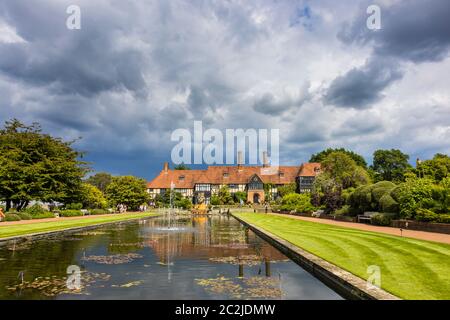 Vue sur le bâtiment historique emblématique du laboratoire le long du canal de Jellicoe sous un ciel gris intense au RHS Wisley Garden, à Surrey, dans le sud-est de l'Angleterre Banque D'Images