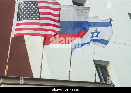 Drapeaux américains, russes et israéliens flottant sur le mur d'un bâtiment à tel Aviv, Israël ; flou de mouvement, attention sélective Banque D'Images