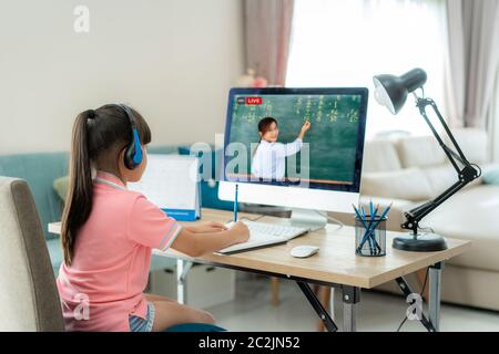 Asiatique étudiant fille vidéo conférence e-learning avec professeur sur ordinateur dans le salon à la maison. E-learning, en ligne, éducation et Internet social dis Banque D'Images