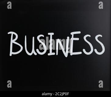 Le mot 'Business' à la main avec craie blanche sur un tableau noir Banque D'Images
