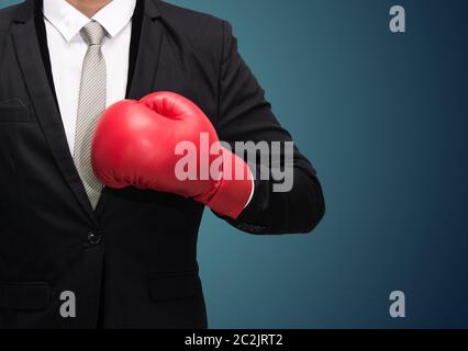 Businessman in boxing gloves posture sur isolé sur fond bleu Banque D'Images