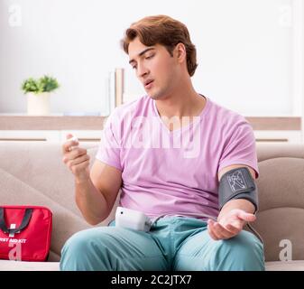 L'homme malade à la maison avec une trousse de premiers secours Banque D'Images