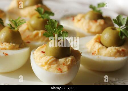 Oeufs farcis épicés garni d'olives vertes et le persil . Banque D'Images
