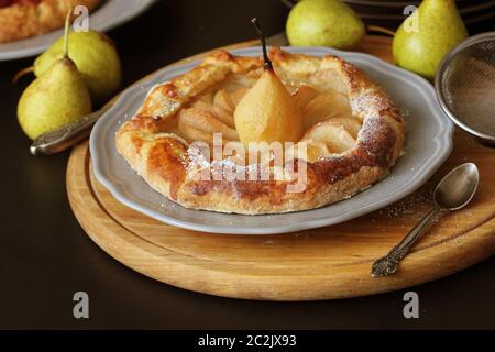 Galette faite maison avec les poires sur fond noir. Cuisine française - galette bretonne. Tarte sucré ouvrir . Banque D'Images