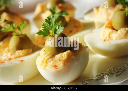 Oeufs farcis épicés garni d'olives vertes et le persil . Banque D'Images