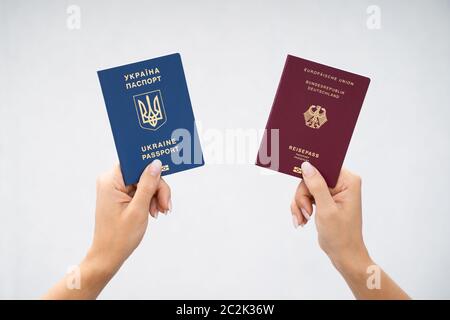 Femme tenant deux passeports. Ukrainiens et allemands Banque D'Images