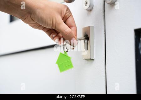 Femme à l'aide d'une clé pour ouvrir la porte de la chambre Banque D'Images