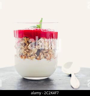 Parfait de granola maison avec confiture de fraises et menthe, yaourt et muesli pour un petit déjeuner sain le matin Banque D'Images