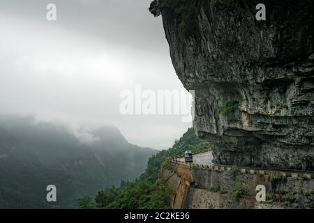 Petit bus prendre des virages dangereux sur la route sinueuse de 99 se tourne vers le haut de la montagne Tianmen, Zhangjiajie Banque D'Images