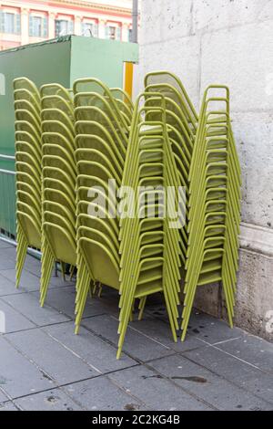 Des chaises en métal vert superposés à l'avant du restaurant Banque D'Images