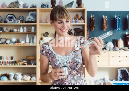 Femme travaillant avec différents types de pierres précieuses dans son magasin Banque D'Images