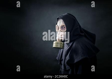 Homme dans un manteau à capuchon et masque à gaz. La pollution de l'environnement. Banque D'Images