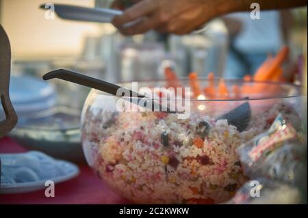 Bol plein d'une salade de riz en appui sur la table lors d'un apéritif pour satisfaire la faim des banquets. Plat typique de la cuisine italienne. Banque D'Images