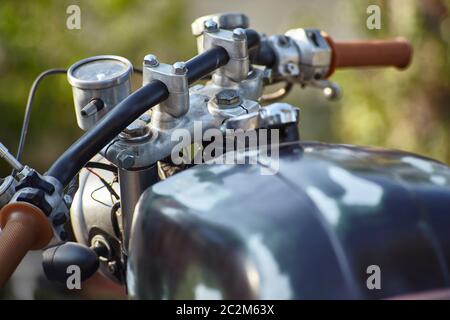 Vue avant du guidon d'une vieille moto de style rat présentant des signes de corrosion et d'usure qui ont mûri avec le temps. Banque D'Images