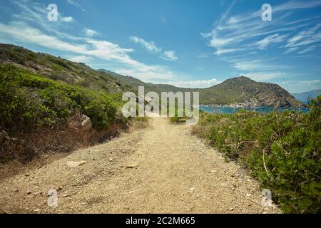 Petit chemin de terre qui longe la côte d'une région du sud de la Sardaigne avec un précipice sur le côté de la mer. Banque D'Images