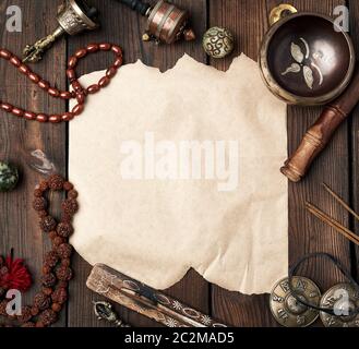 objets religieux tibétains pour la méditation et la médecine alternative, feuille de papier brune vide froissée sur fond de bois brun, vue de dessus Banque D'Images