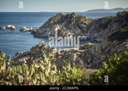 Belle baie naturelle dans les montagnes de granit dans la région de Capo Ferrato, dans le sud de la Sardaigne à l'été éclairé par le coucher du soleil. Banque D'Images