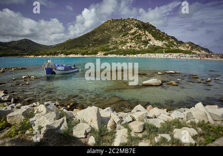 Belle vue de Punta Molentis, une plage naturelle sur la côte sud de la Sardaigne, avec un couple de petits bateaux de pêche amarrés sur la rive. Banque D'Images