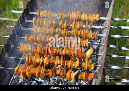 Pommes de terre et bakons sur brochettes cuisant au feu. Déjeuner-barbecue. Shashlik mariné à partir de pommes de terre et de ba Banque D'Images