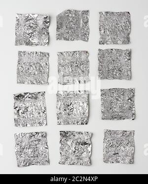 diverses feuilles d'aluminium froissés utilisaient des enveloppeurs de bonbons sur un fond blanc, vue de dessus Banque D'Images