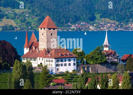 Vue aérienne de l'Église et Château de Spiez sur les rives du lac de Thoune, dans le canton suisse de Berne au coucher du soleil, Spiez, Suisse. Banque D'Images